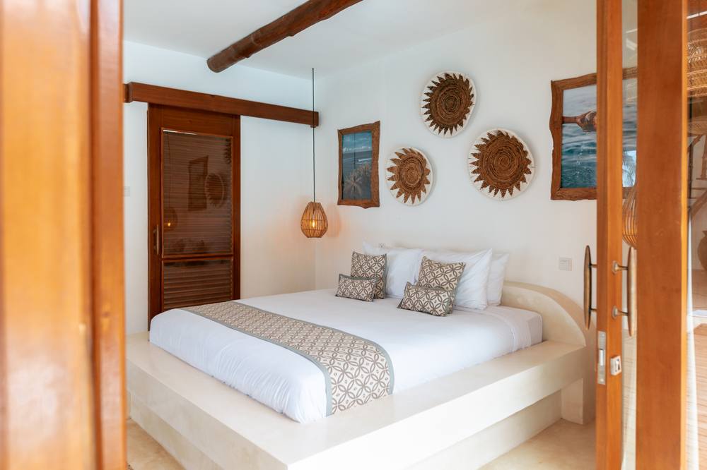 Villa Onu's thatched-roof beachfront deck with lounge seating