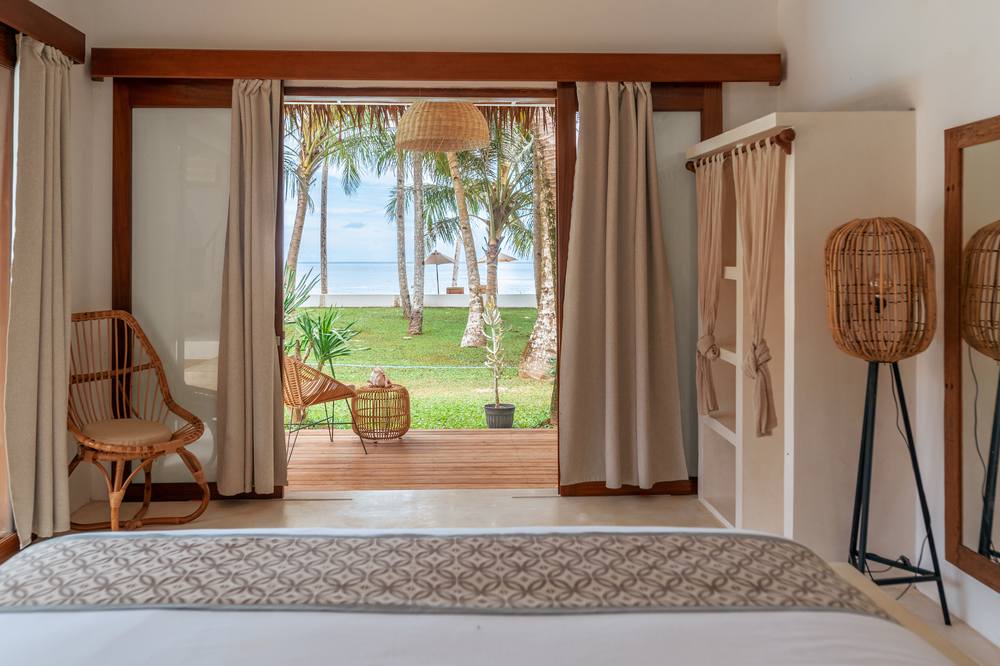 Villa Onu's thatched-roof beachfront deck with lounge seating