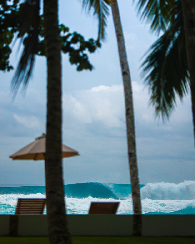 Villa Onu's thatched-roof beachfront deck with lounge seating